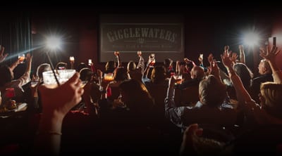 Guests raising drinks during movie screening at Gigglewaters Social Club in Safety Harbor FL
